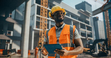 Portrait of a Handsome Black Civil Engineer Working on a Tablet at a Construction Site. Young...