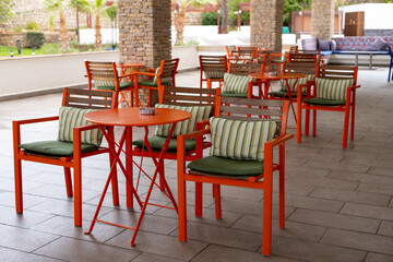 Colorful outdoor seating area in a modern cafe with vibrant chairs and cushions