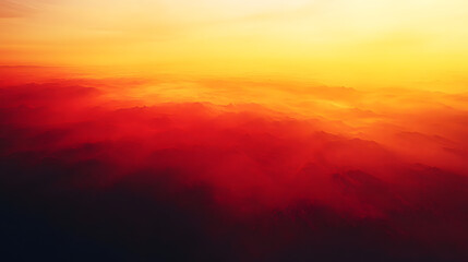 Fiery sunset over a vast mountain range, clouds bathed in vibrant orange and red hues.  A breathtaking aerial view of nature's fiery spectacle.