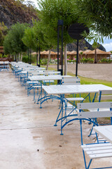 Fototapeta premium Outdoor seating arrangement along a scenic pathway near a mountain landscape