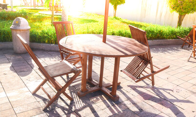 folding table chairs from the garden with green grass and afternoon sunlight. cafe table chairs set by the swimming pool