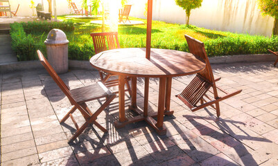 folding table chairs from the garden with green grass and afternoon sunlight. cafe table chairs set by the swimming pool