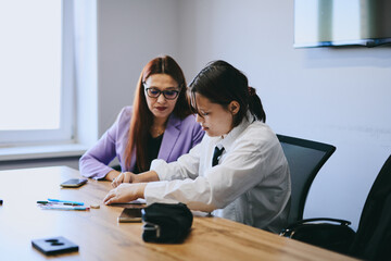Schoolgirl and teacher have a lesson in the office, private lessons, distance learning