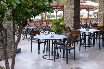 Outdoor dining area with empty tables nestled under rustic architecture