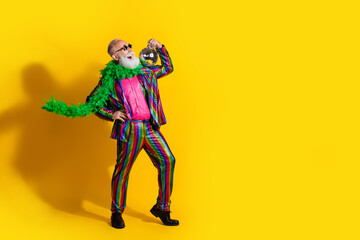 Full length photo of elderly cool mac old man dance hold discoball wear stylish striped suit boa sunglass isolated on yellow background