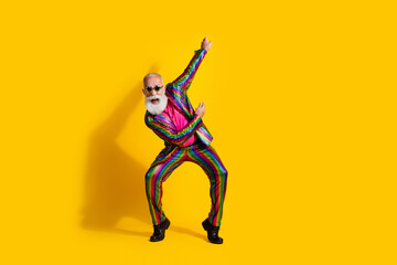 Full body portrait of eccentric man dance move empty space wear shiny costume isolated on yellow color background