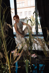 Red-haired girl in overalls in artificial pond in studio