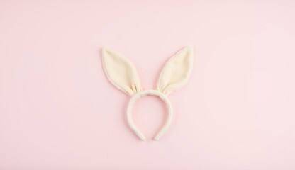 Fototapeta premium Cute plush bunny ears headband on pastel pink background, perfect for Easter celebration