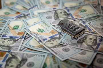 Car Key on US 100 Dollar Bills Background, Concept of Wealth and Vehicle Ownership