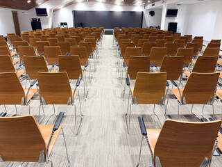 empty room with wooden chairs and a ledwall