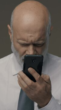 Middle-aged man having difficulties and vision problems using his smartphone