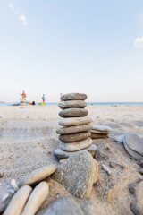 Perfectly balanced stack of stones on a sandy beach, symbolizing tranquility and mindfulness.