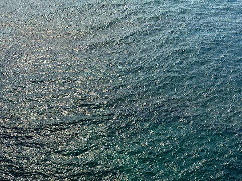 Ocean water glittering calm blue ripples surface. 