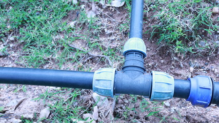 HDPE plastic water pipe connector. Close-up of old HDPE plastic three-way connector for connecting...