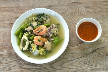 boiled sukiyaki seafood chicken and pork meat couple crispy pickled squid and shrimp with vegetable in soup on plate dipping sauce