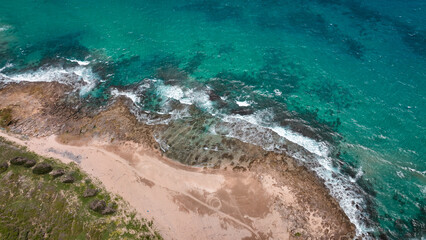 Aerial view of the coastline at Longpan Park in Taiwan with clear blue water and sandy shores