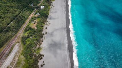Aerial view of a tranquil beach in Taiwan showcasing clear blue water and a sandy shoreline