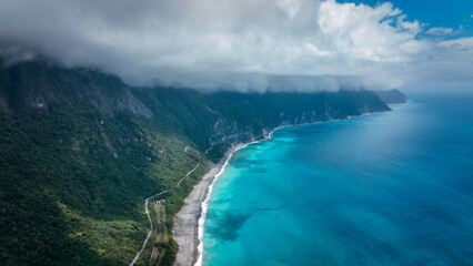 Breathtaking view of Taiwan coastline with azure waters and lush mountains under a cloudy sky