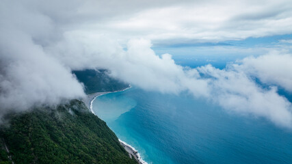 Aerial view of Taiwan coastline with mountains and cloudy skies on a serene day