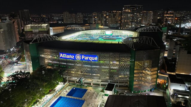Vista a&eacute;rea noturna do Allianz Parque, est&aacute;dio do Palmeiras em S&atilde;o Paulo, Brasil. Destaque para a ilumina&ccedil;&atilde;o vibrante e o contraste com o cen&aacute;rio urbano ao redor. S&atilde;o Paulo, SP em 26 Nov 2024