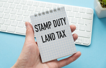 SDLT - Stamp Duty Land Tax write on a Notebook in hand on office desk.