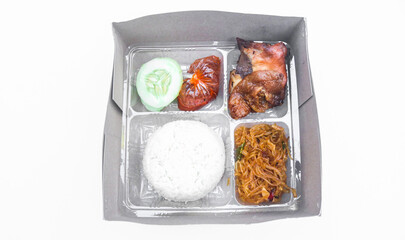 Indonesian boxed rice with grilled chicken, fried noodles, sambal isolated on white background. Boxed rice for celebration or catering packaging as lunch box