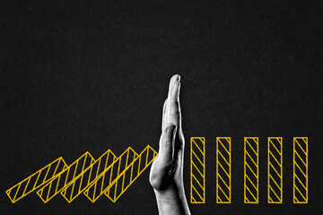 Hand Stopping Domino Blocks in  Black and White on Textured Paper Background, Copy Space. Business...