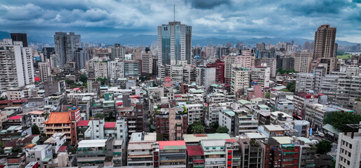 Taipeis skyline features dense urban life and tall buildings beneath cloudy skies