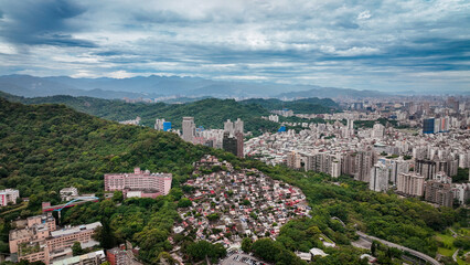 Aerial view of vibrant Taipei city landscape surrounded by lush mountains and greenery