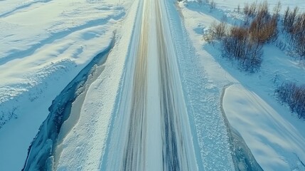 A bridge spanning a frozen river, viewed from above in a winter setting.

