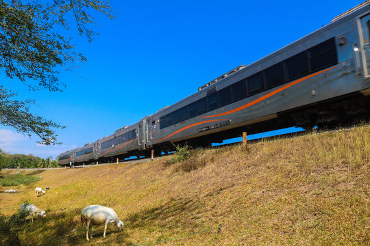 Indonesia - August 3, 2024: Indonesian train by on the tracks through the countryside with views of grasslands and blue skies. Kereta Api indonesia (KAI)