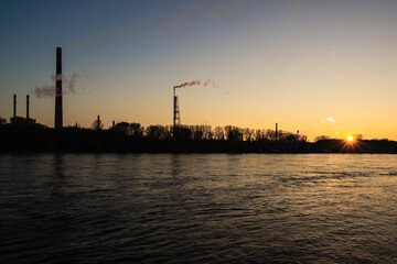 Industrial chimneys on the Rhine in the light of the setting sun.