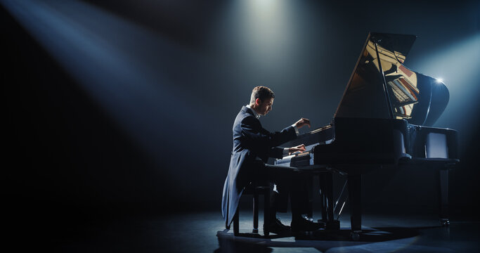 Masterful Music Artist Performing on a Dark Empty Stage, His Hands Moving Effortlessly Over the Grand Piano. Sophisticated Musician Brings a Dramatic and Emotional Composition to Life