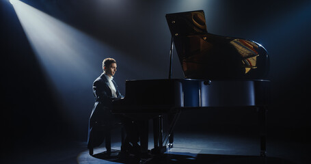 Young Pianist Playing Academic Music, Performing Classical Solo Compositions on a Dark Stage. Grand...