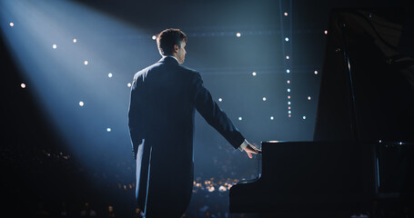 Male Pianist in a Ceremonial Tailcoat Standing on Stage with a Black Grand Piano, Ready to Play a...