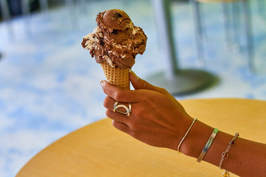 woman holding a chocolate ice cream cone
