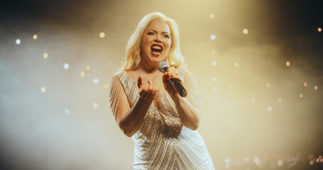 Portrait of a Blonde Pop or Rock Musician Holding a Microphone to Sing a Powerful Hit Song in a...