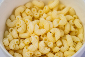 Yellow elbow macaroni on a bowl isolated. Elbow macaroni isolated. Italian food.