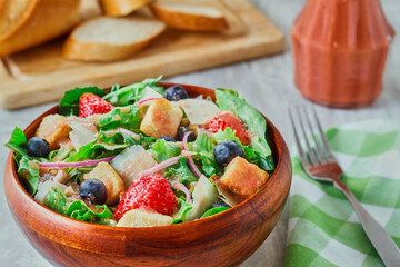 a mixed salad topped with a strawberry vinaigrette