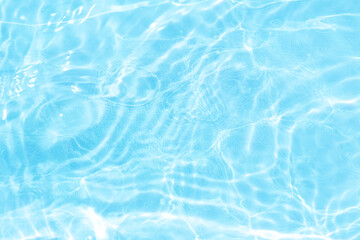 Blue water with ripples on the surface. Defocus blurred transparent blue colored clear calm water surface texture with splashes and bubbles. Water waves with shining pattern texture background.