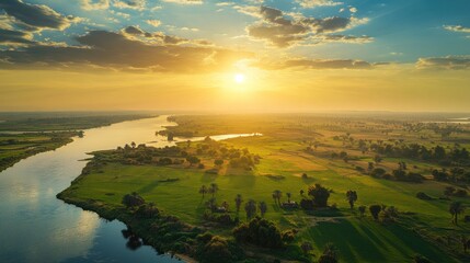 Golden Sunset Over Serene River and Lush Landscape with Expansive Sky Views