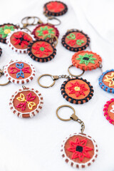 A beautiful set of terracotta keychains with colorful embroidery, each piece showcasing vibrant patterns and handmade artistry, perfect for creating unique home decor or gifting