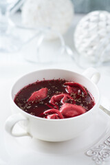 Traditional Christmas Borscht (Barszcz) with mushroom dumplings on bright background.	
