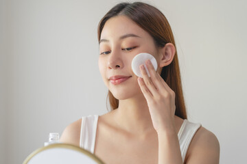 Close-up view woman using toner and cotton pad to remove makeup
