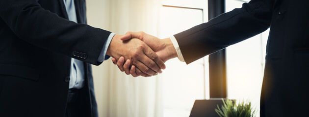 close-up view hands of agent and client shaking hands after signed contract buy new apartment.