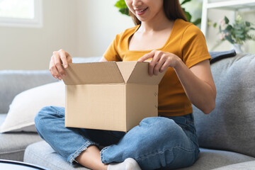 Close-up hands of Excited Young females opening box at home