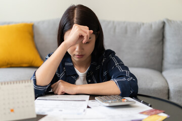 young asian woman cover her face after stressed with monthly bill expenses and credit card debt.