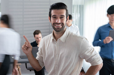 Confidence and happy smiling businessman portrait with blur motion background of his colleague and business team working in office. Office worker teamwork and positive workplace concept. Prudent