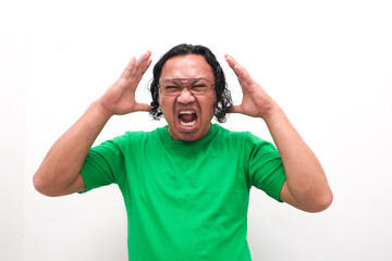 An Asian man in a green shirt exhibits a fierce expression, baring his teeth and raising his hands...
