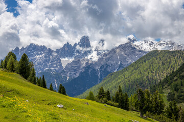 Fototapeta premium Dolomites mountains nasty weather in autumn with dark cloudy sky before the storm. Black clouds on the sky above the mountain rocky summits and peaks, stormy weather in the Dolomiti Alps, Italy. Extre